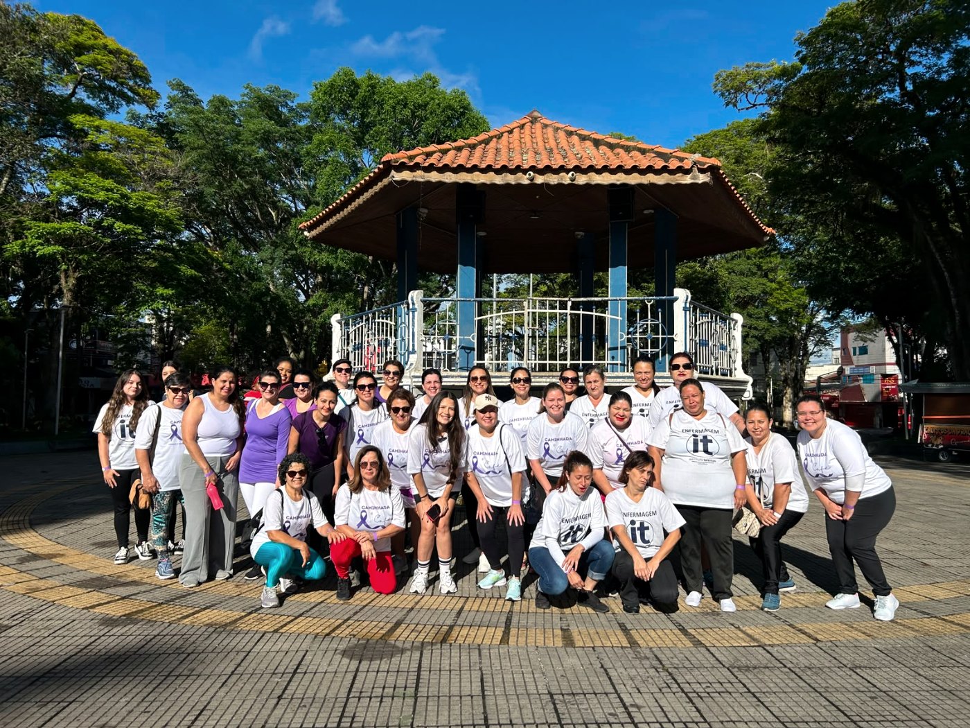 Mulheres da Caminhada pela Mulher reunidas diante do coreto da praça