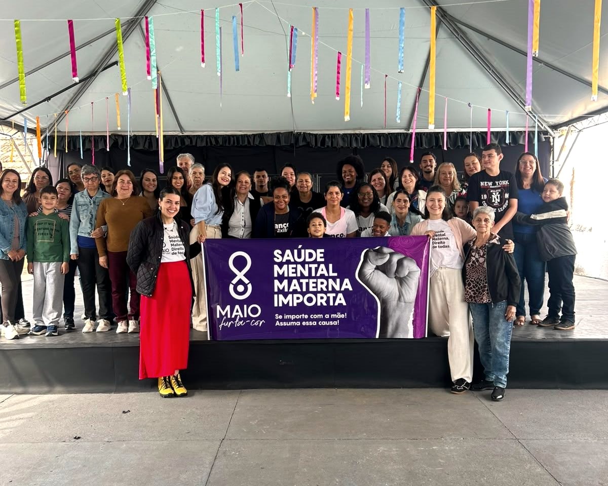 Grupo com a faixa Saúde Mental Materna Importa, do Maio Furta-Cor