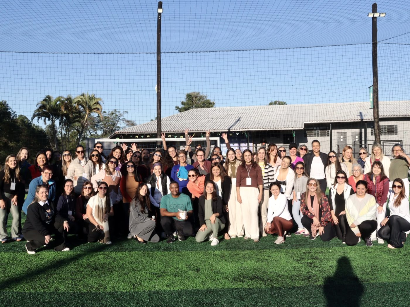 Participantes do evento Quem Cuida de Quem Cuida? reunidas em um campo ao ar livre