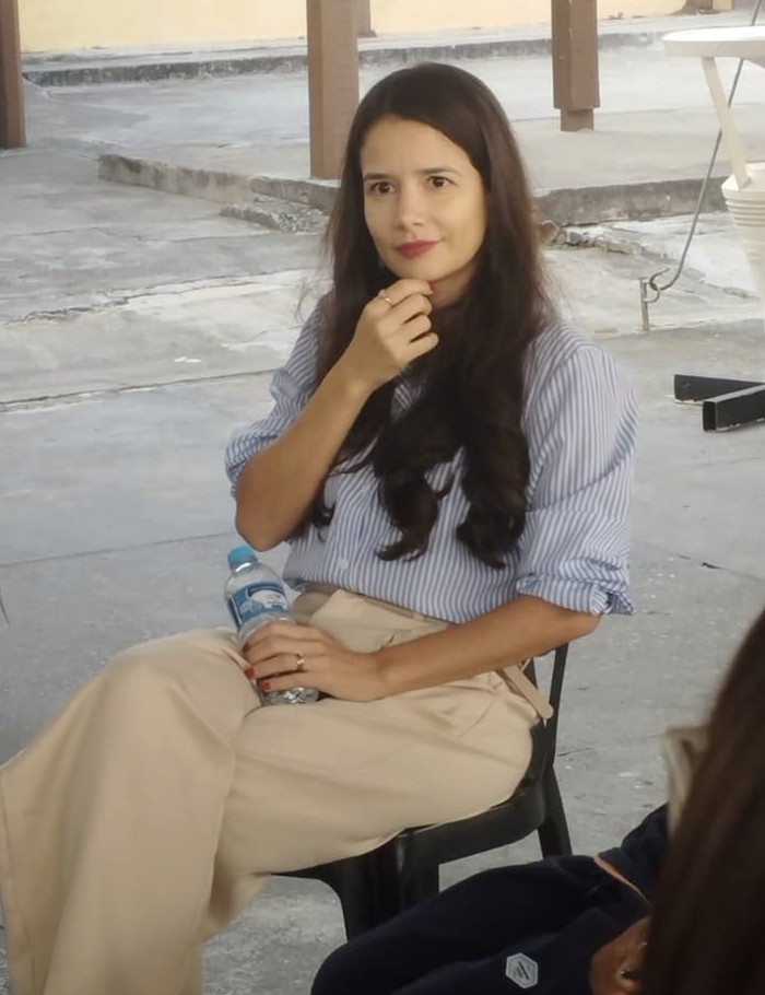 Aline Beringhs sentada numa roda de conversa, escutando com atenção